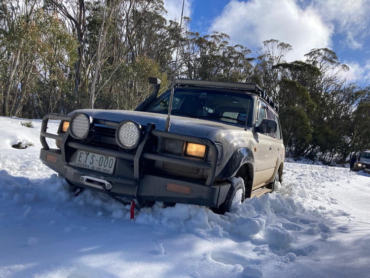 Toyota Landcruiser 80 Series in snow, ARB bull bar. Land Rover Defender in background fitted with Recovery Gear. recoverygear.com.au. 